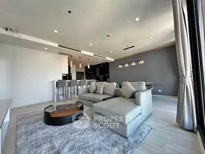 Spacious modern living room with elegant decor and open layout, featuring a cozy sectional sofa and stylish lighting.