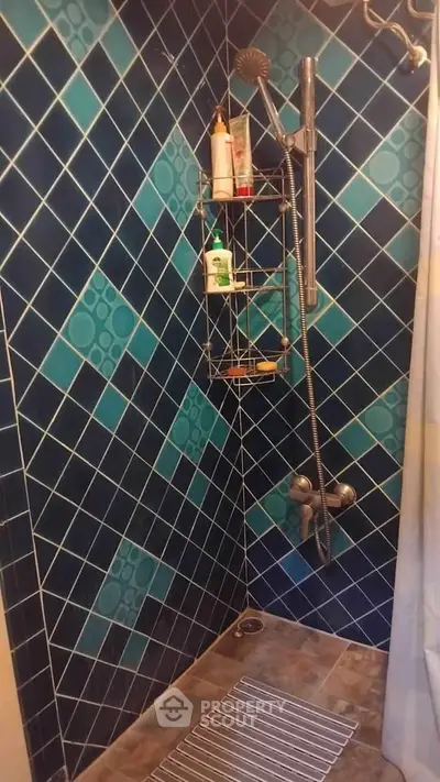 Stylish bathroom shower with blue tiled walls and modern fixtures