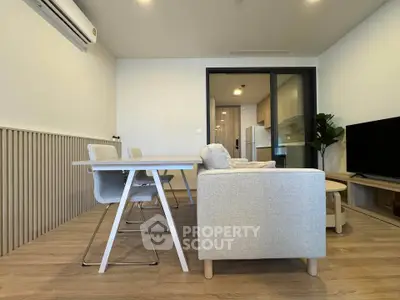 Modern living room with stylish furniture and open layout, featuring a cozy dining area and sleek decor.