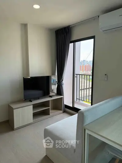 Modern living room with balcony view, featuring sleek furniture and natural light.