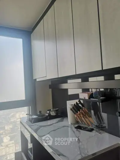 Modern kitchen with sleek cabinets and marble countertop in high-rise apartment