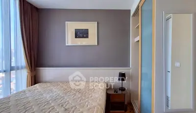 Modern bedroom with large window and stylish decor in a high-rise apartment.