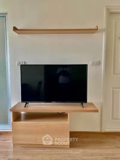 Modern living room with sleek TV stand and wall-mounted shelf