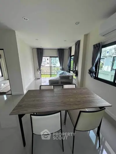 Modern dining area with large windows and natural light in a stylish apartment.