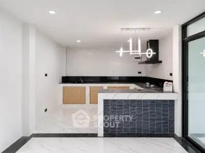 Modern kitchen with sleek design, featuring open layout and stylish lighting in a contemporary apartment.