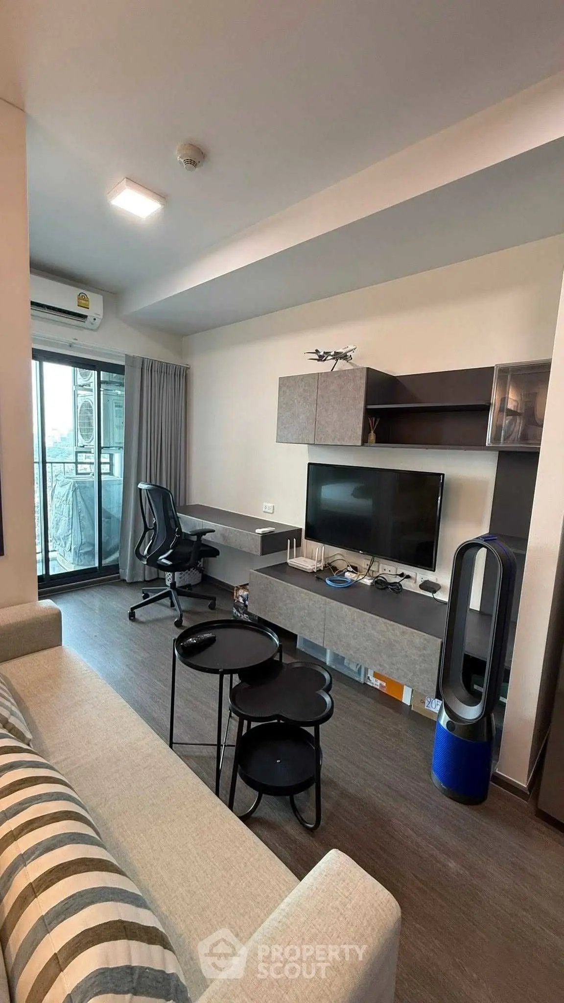 Modern living room with sleek furniture and balcony view in a stylish apartment.