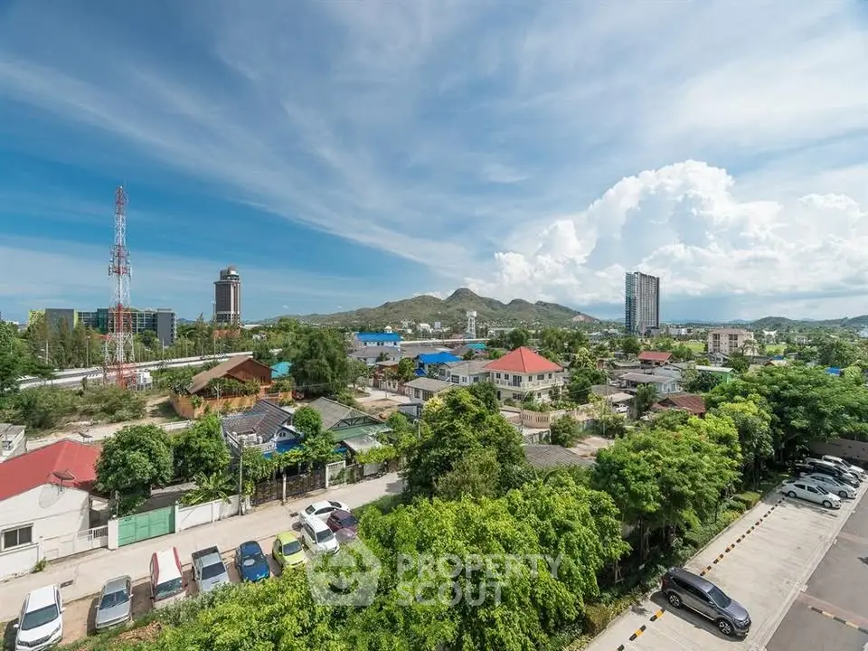Scenic view of suburban neighborhood with lush greenery and distant mountains under a clear blue sky.