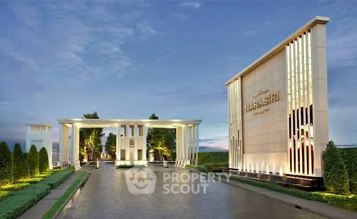 Luxurious entrance of upscale residential community with elegant architectural design and lush landscaping.