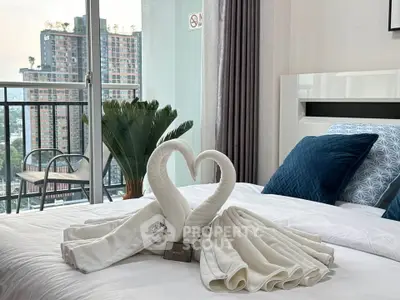 Luxurious bedroom with elegant decor and stunning city view from balcony.
