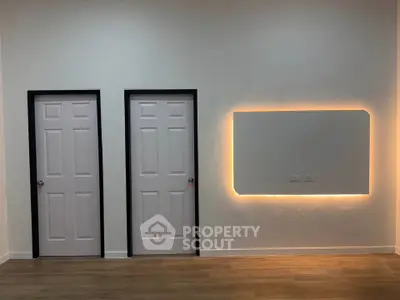 Modern interior with two doors and stylish illuminated wall feature
