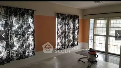 Spacious living room with large windows and modern curtains, ideal for natural light.
