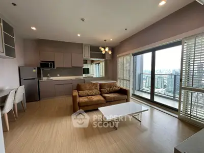 Spacious modern living room with open kitchen and stunning city view balcony.