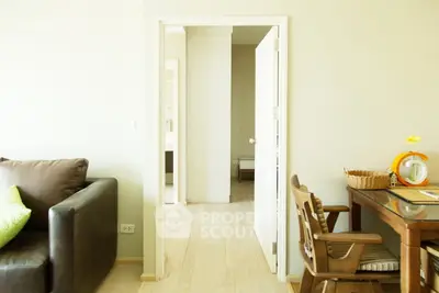 Bright and cozy living room with modern furniture and open doorway leading to other rooms.