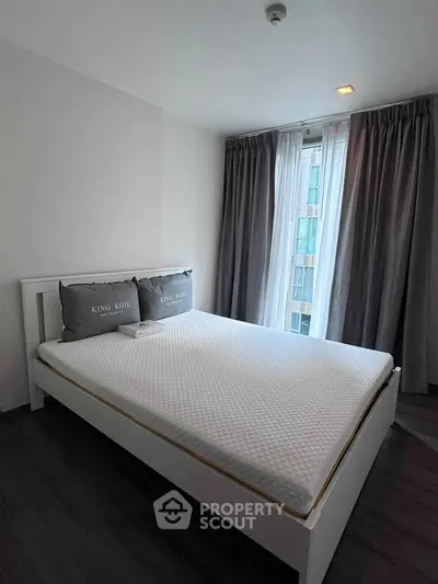 Modern bedroom with large window and stylish curtains in a contemporary apartment.