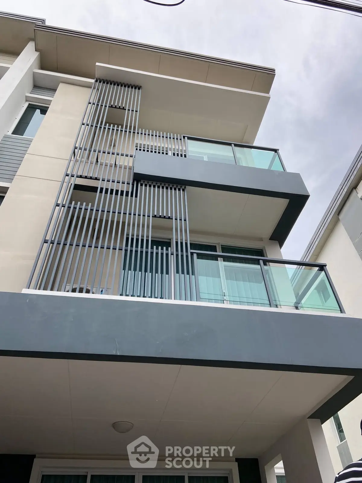 Modern multi-story building with sleek balconies and glass railings, showcasing contemporary architectural design.