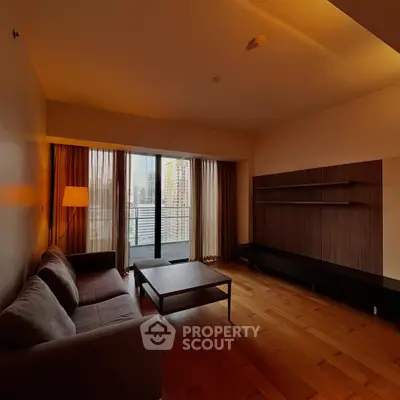 Spacious living room with modern decor and city view balcony.