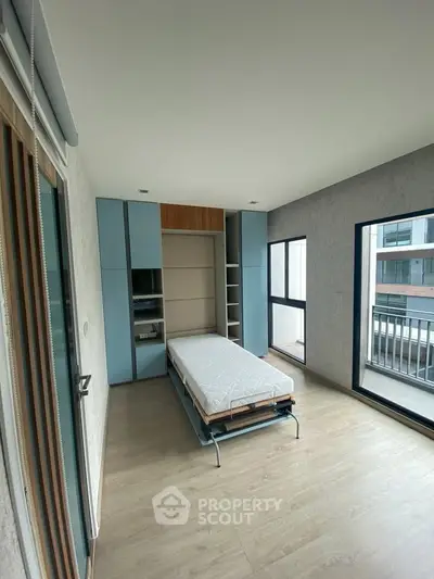 Modern bedroom with foldable bed and large windows in a stylish apartment.