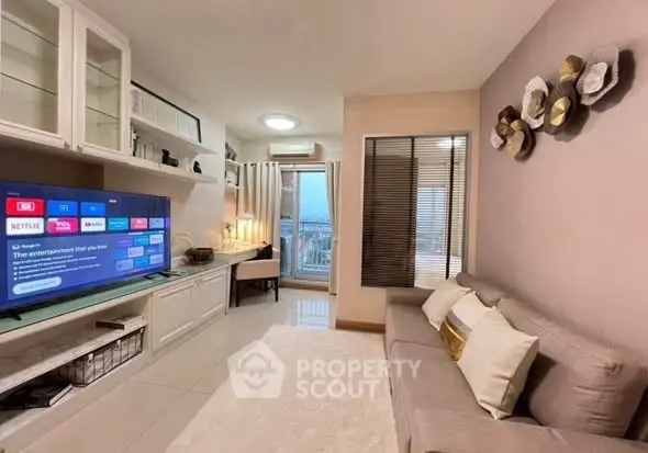 Modern living room with stylish decor and large TV, perfect for relaxation.