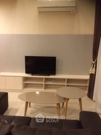 Modern living room with sleek TV setup and stylish coffee tables