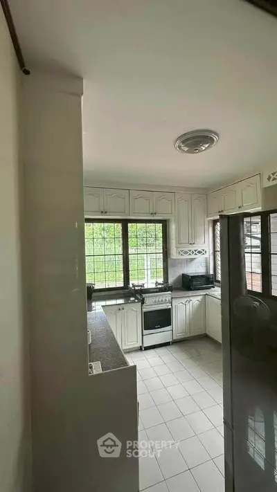 Spacious kitchen with modern appliances and large windows for natural light.