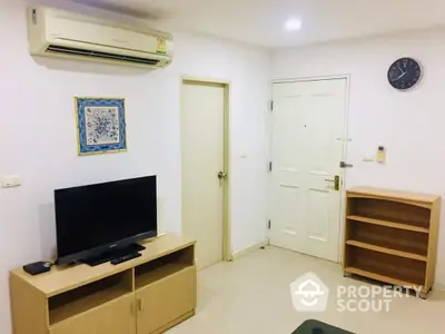 Cozy and well-maintained living space featuring a modern entertainment unit, air conditioning, and a clean, minimalist design.