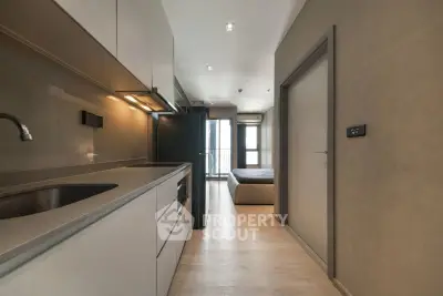 Modern apartment interior with sleek kitchen and cozy bedroom view.
