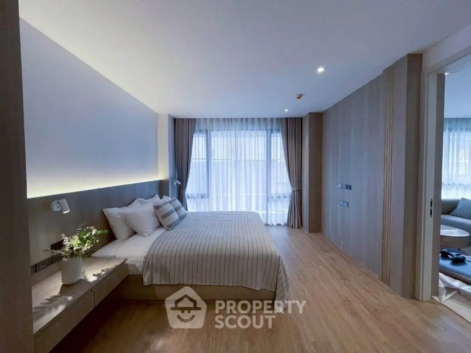 Spacious modern bedroom with elegant decor and large windows for natural light.