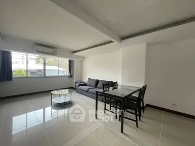 Spacious living room with modern furniture and large window view