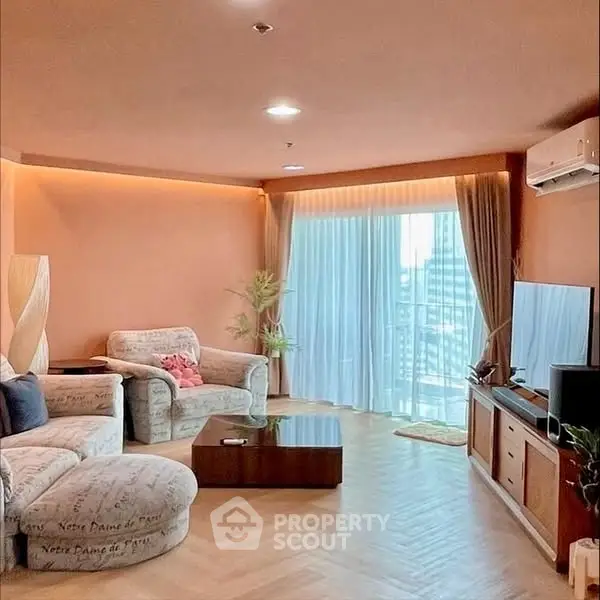 Spacious living room with modern decor and city view balcony.