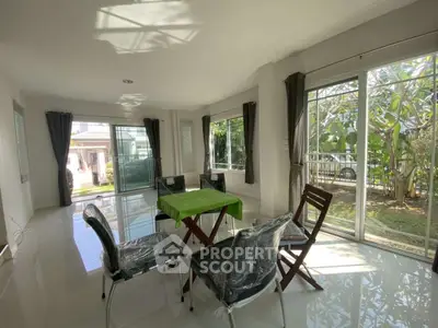 Spacious living room with large windows and garden view, perfect for natural light lovers.