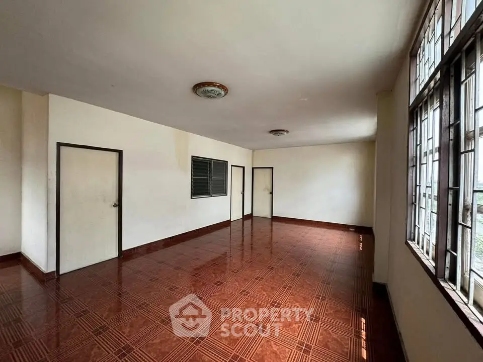 Spacious empty room with large windows and tiled flooring, ideal for customization.