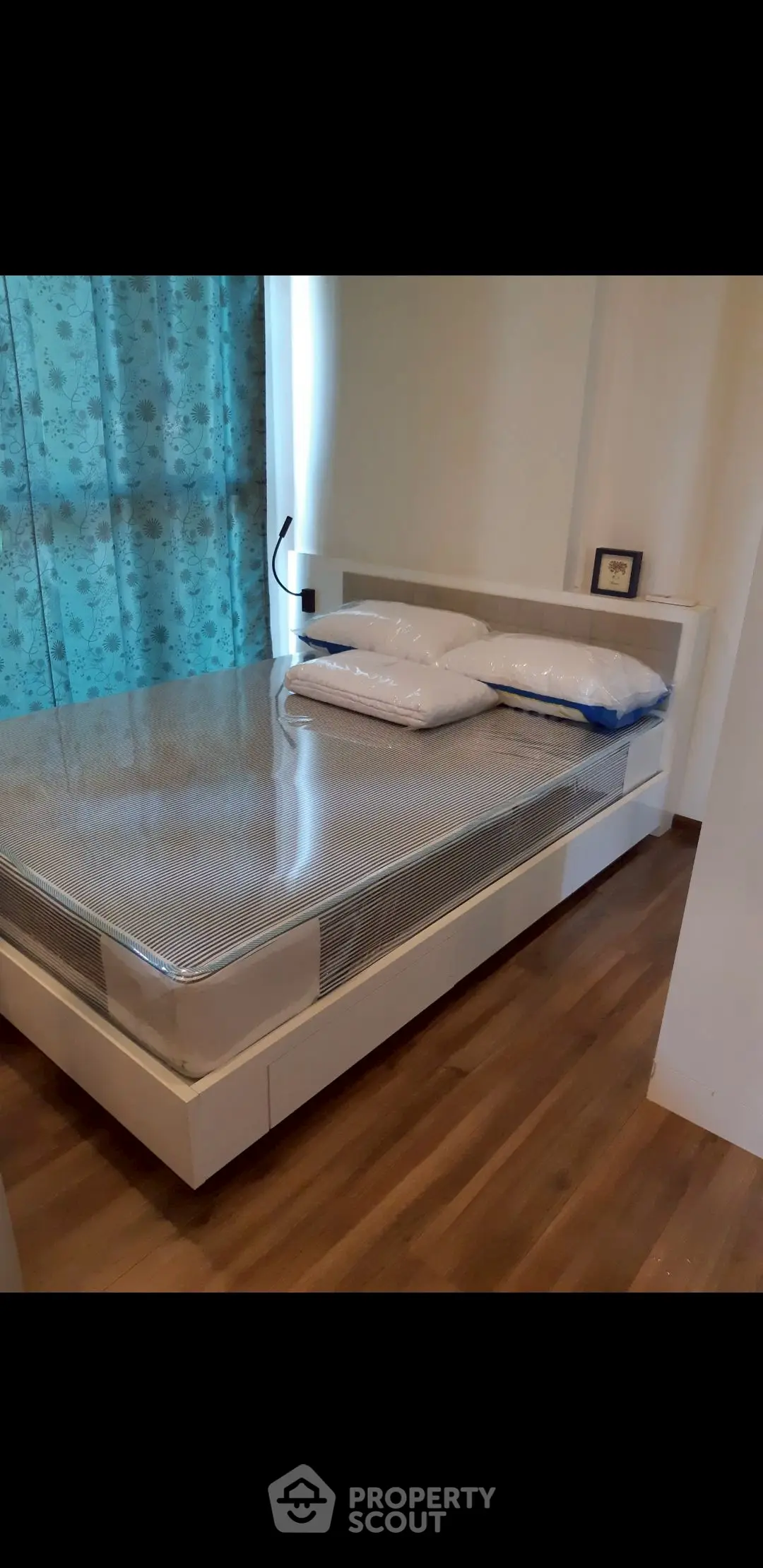 Cozy bedroom with modern bed and wooden flooring, ideal for restful nights.