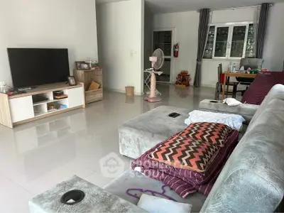 Spacious living room with modern furniture and large TV, perfect for family gatherings.