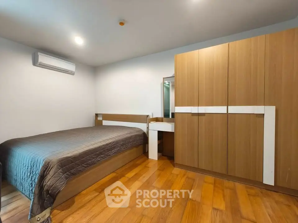 Modern bedroom with wooden flooring and sleek furniture design