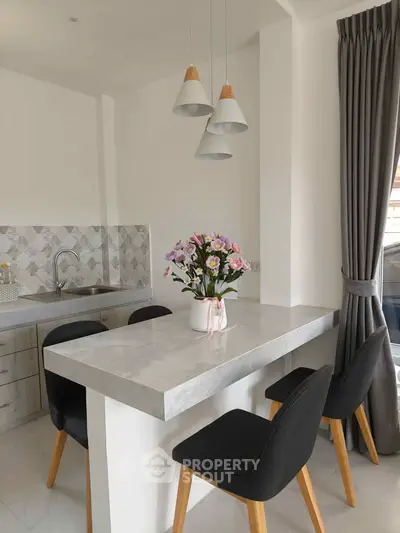 Modern kitchen with elegant marble countertop and stylish pendant lights, perfect for contemporary living.