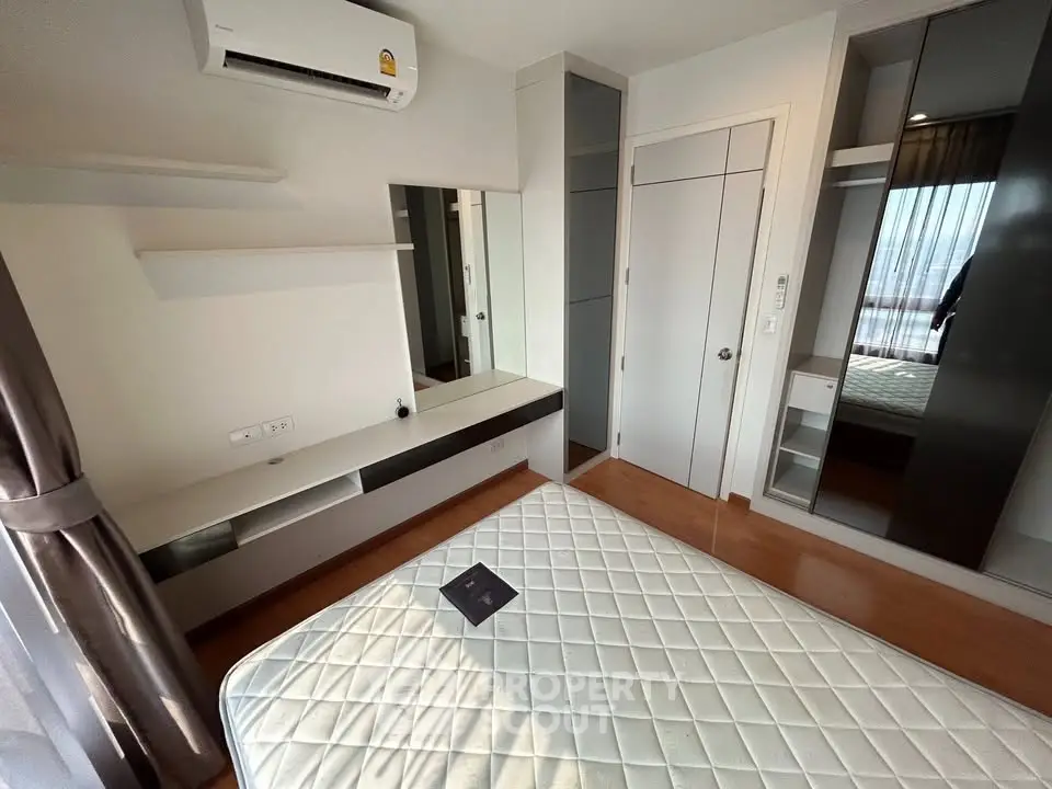 Modern bedroom with built-in wardrobe and air conditioning in a stylish apartment.