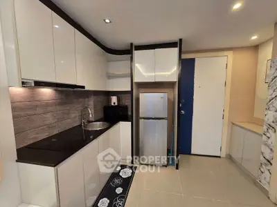 Modern kitchen with sleek cabinetry and stainless steel appliances in a stylish apartment.