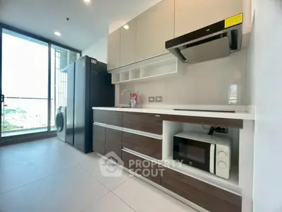 Modern kitchen with sleek cabinets, appliances, and large window view