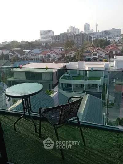Stunning balcony view with modern glass railing overlooking cityscape and rooftops, perfect for relaxation.