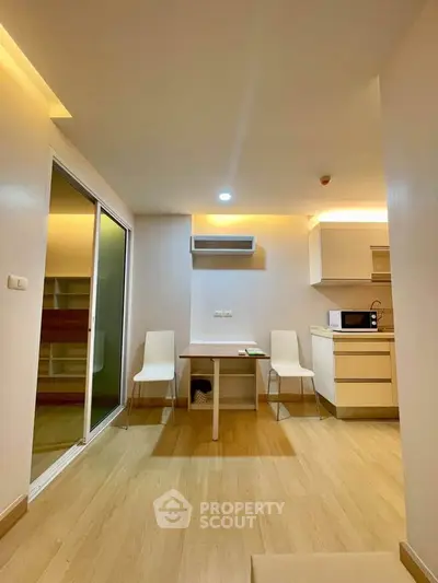 Modern apartment interior with open kitchen and dining area, featuring sleek design and ample natural light.