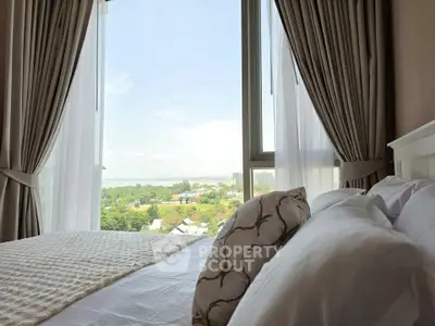 Luxurious bedroom with stunning view through large window, elegant curtains, and plush bedding.