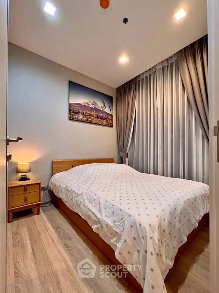 Cozy bedroom with modern decor and soft lighting, featuring a comfortable bed and elegant curtains.