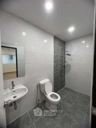 Modern bathroom with sleek gray tiles and contemporary fixtures in a stylish apartment.