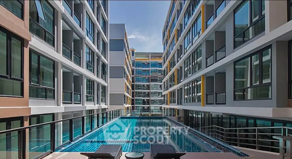 Modern apartment complex with a stunning central pool and sleek architectural design.