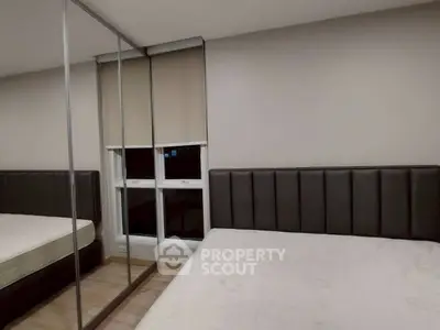 Modern bedroom with mirrored wardrobe and twin beds in stylish apartment.