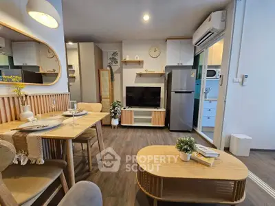 Modern living room with dining area, stylish furniture, and kitchen appliances in a cozy apartment.