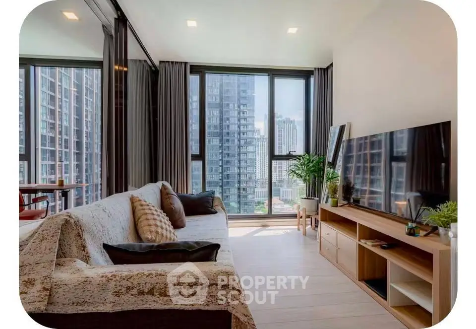 Modern living room with large windows and city view, featuring stylish furniture and decor.