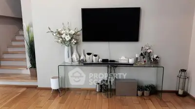 Modern living room with sleek TV setup and elegant decor on wooden flooring.