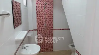 Modern bathroom with red mosaic tiles and sleek fixtures