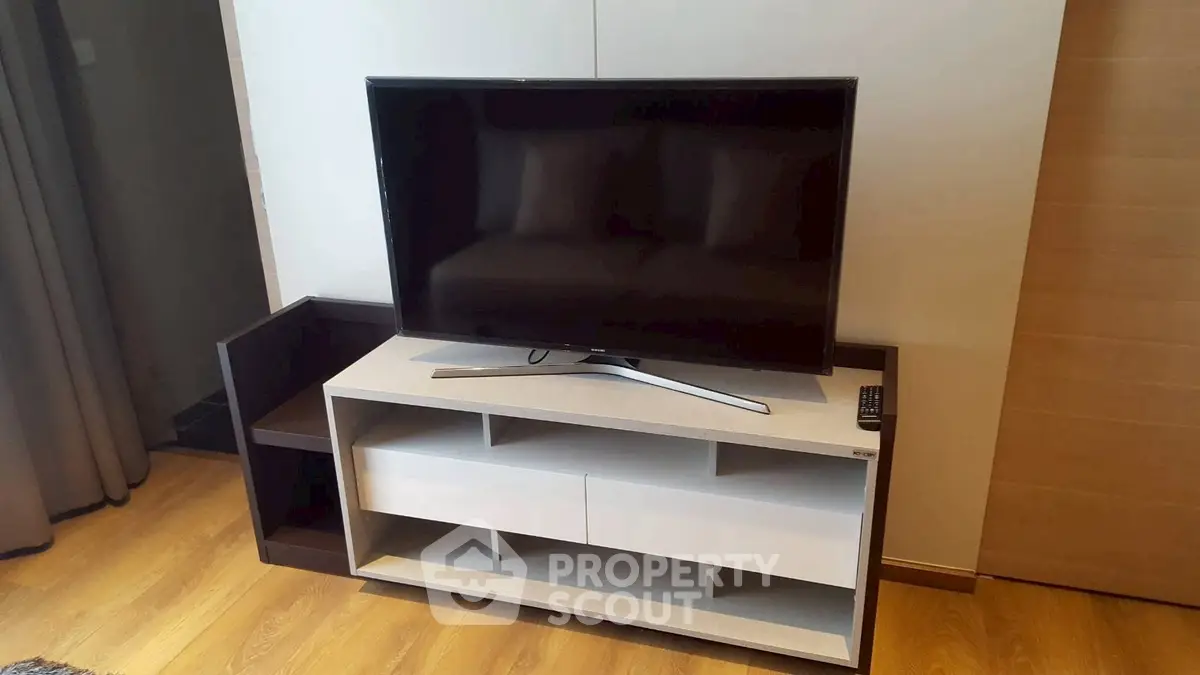 Modern living room with sleek TV stand and flat-screen television, perfect for entertainment.